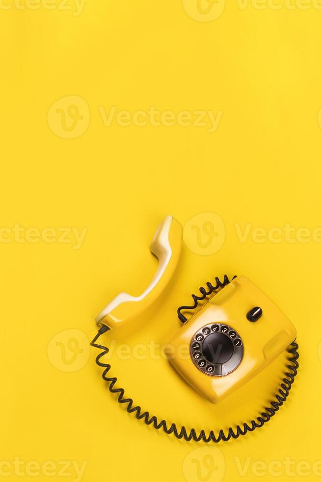 Vertical banner with old yellow phone with hard shadows on yellow background flat lay copy space for you text photo