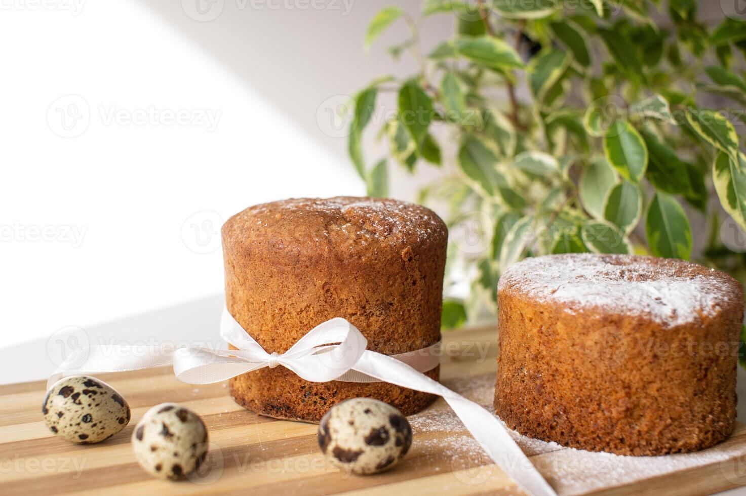 Sponge cake with powdered sugar on the table with quail eggs. A green plant. Place for text photo