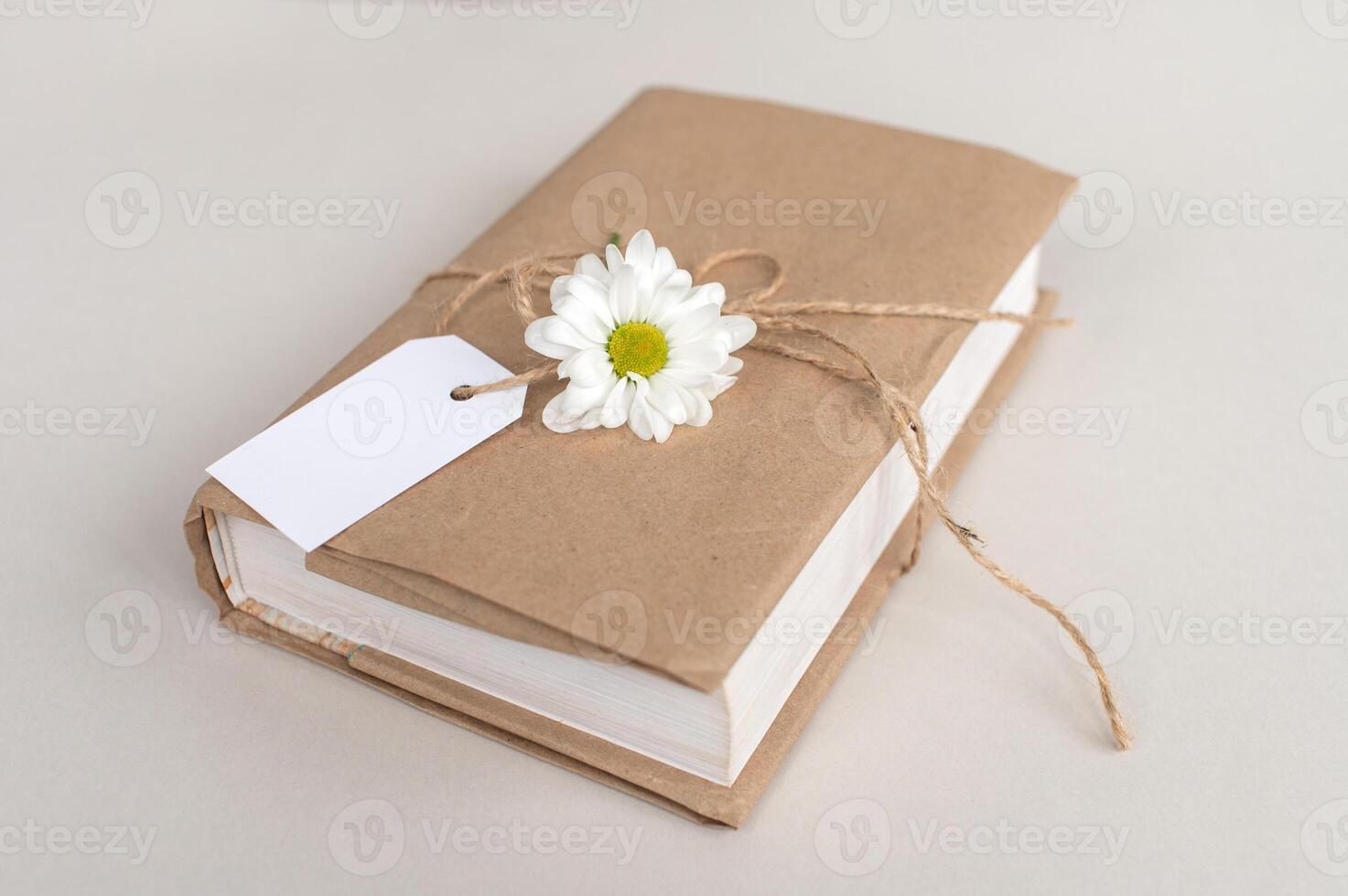 Kraft cover book with white tag, gift wrapping, top view, white label, mockup for text photo
