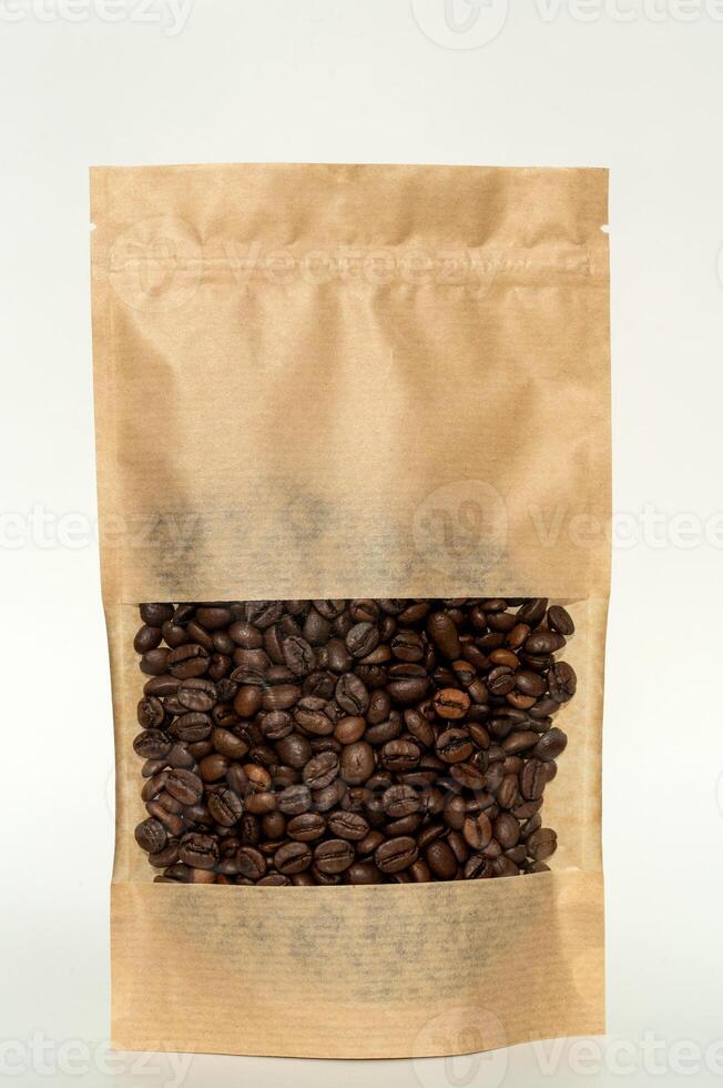 A kraft paper bag with coffee beans for viewing with a highlighted shadow lies on a white background photo