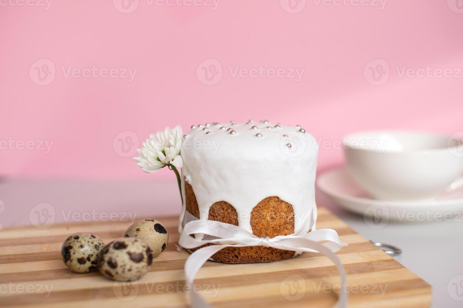 Easter cake with white icing and silver sprinkles, accompanied by quail eggs photo