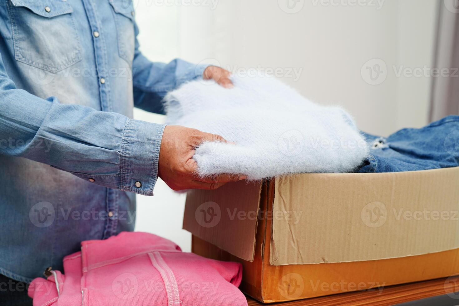 Clothes donations in cardboard box for volunteer. photo