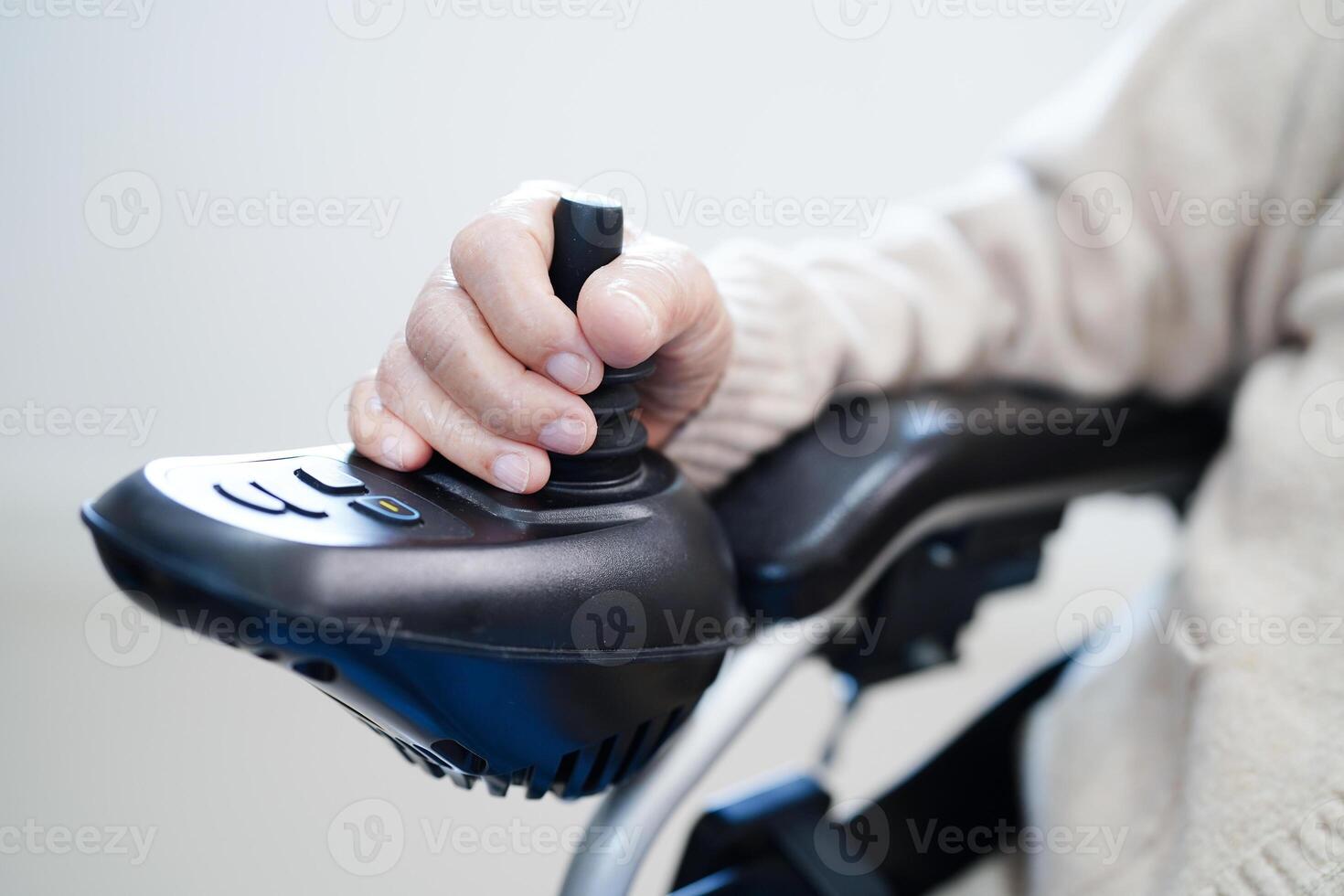 Asian elderly disability woman patient use joystick electric wheelchair in hospital. photo