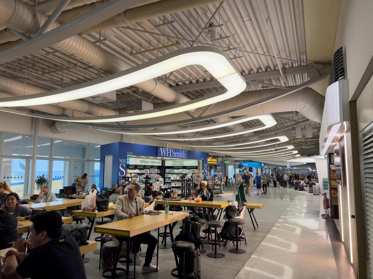 Afines, Greece - 20 august 2023. Passengers sit at tables in the airport lounge photo