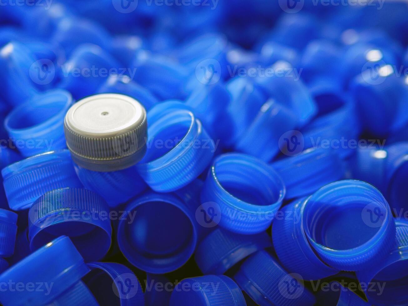 Grey plastic bottle caps on top to depict the concept of standing out from the crowd, dare to be different, odd man out, success or a leadership concept. photo