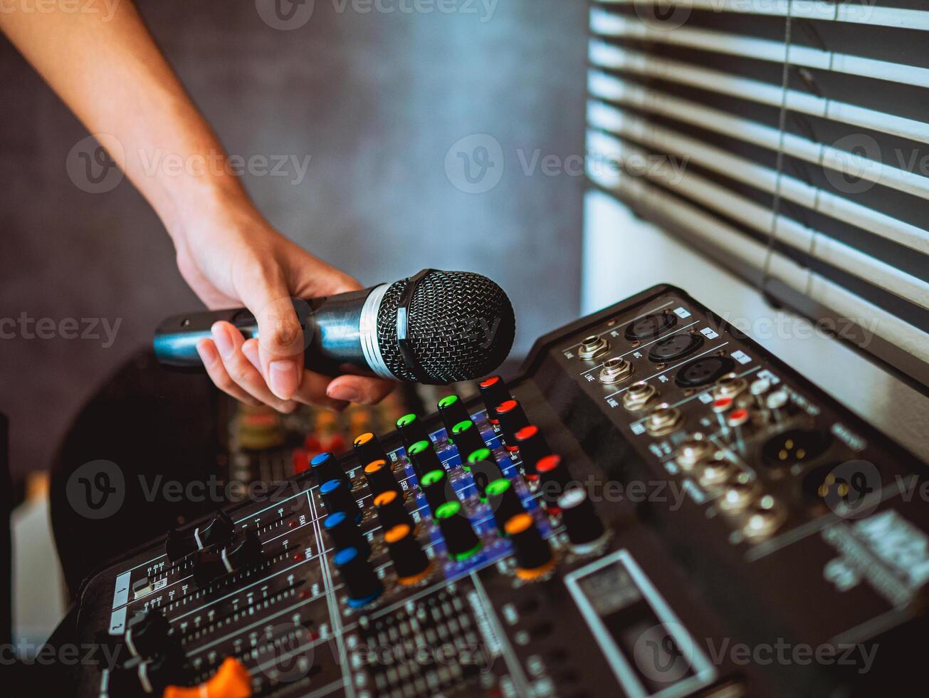 Hand Sound engineer  holding microphone on sound mixer in live broadcasting studio producer for sound record control system production and audio equipment and music instrument photo