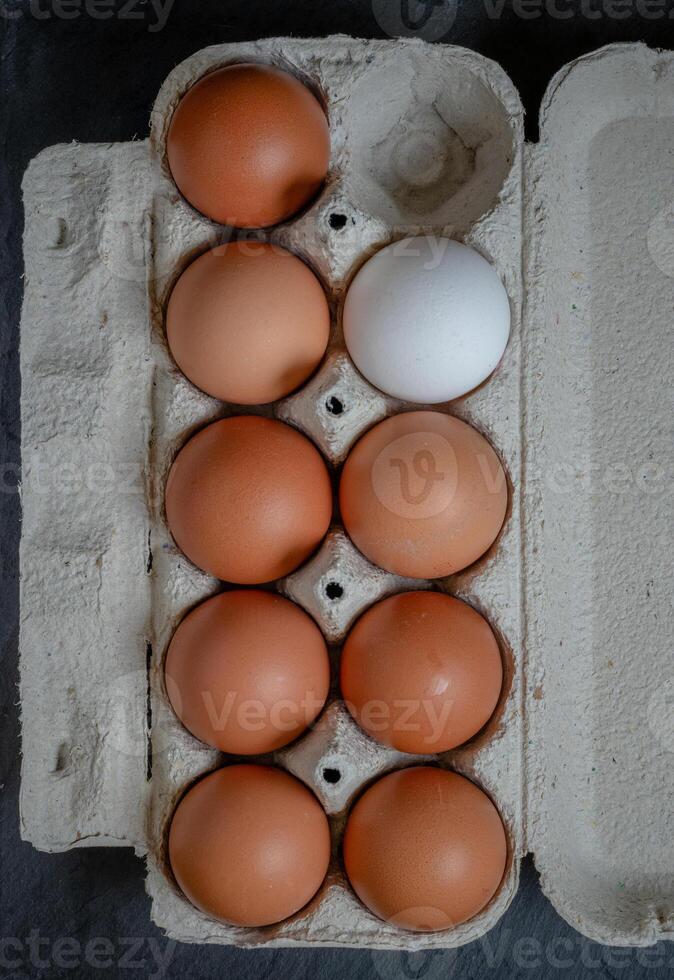 Fresh chicken eggs in a paper tray on the table, selective focus photo