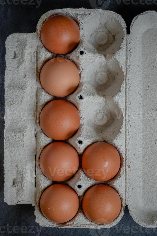 Fresh chicken eggs in a paper tray on the table, selective focus photo