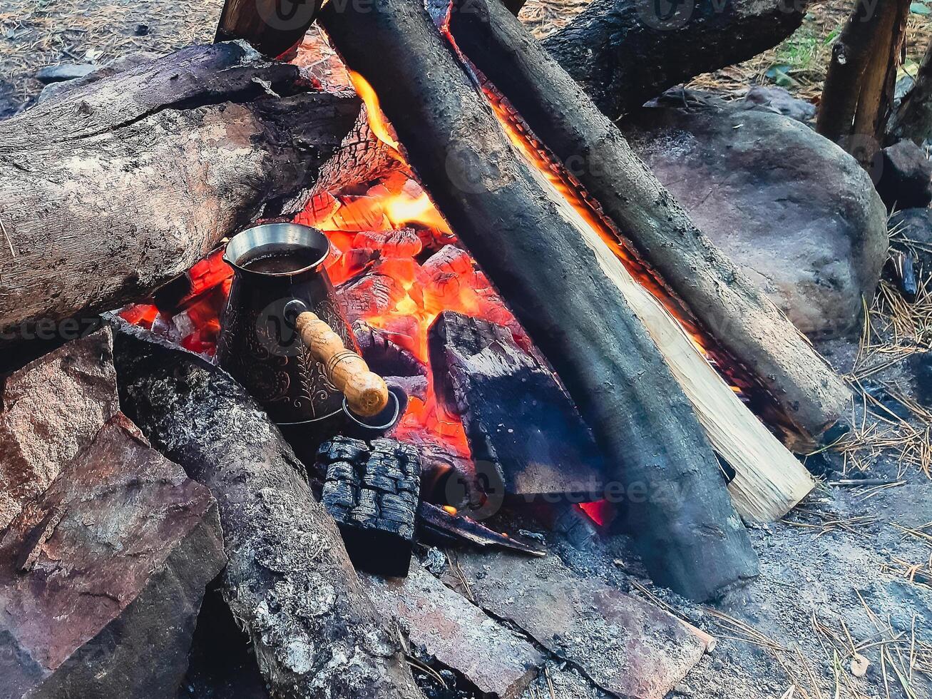 Brew coffee in a Turk on an open fire. photo