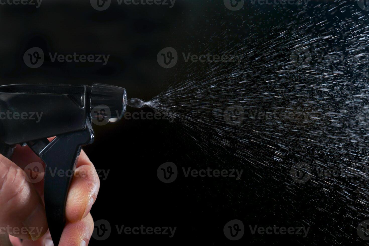 a man's hand pressing the trigger of a sprayer, photo
