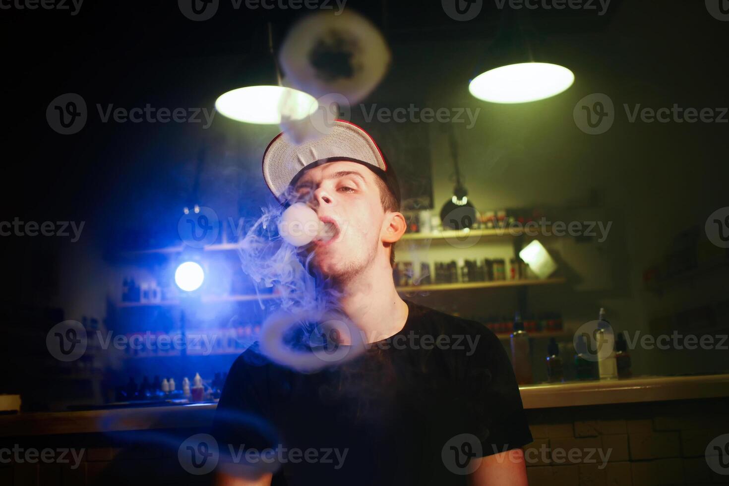 The man smoke an electronic cigarette at the vape shop photo