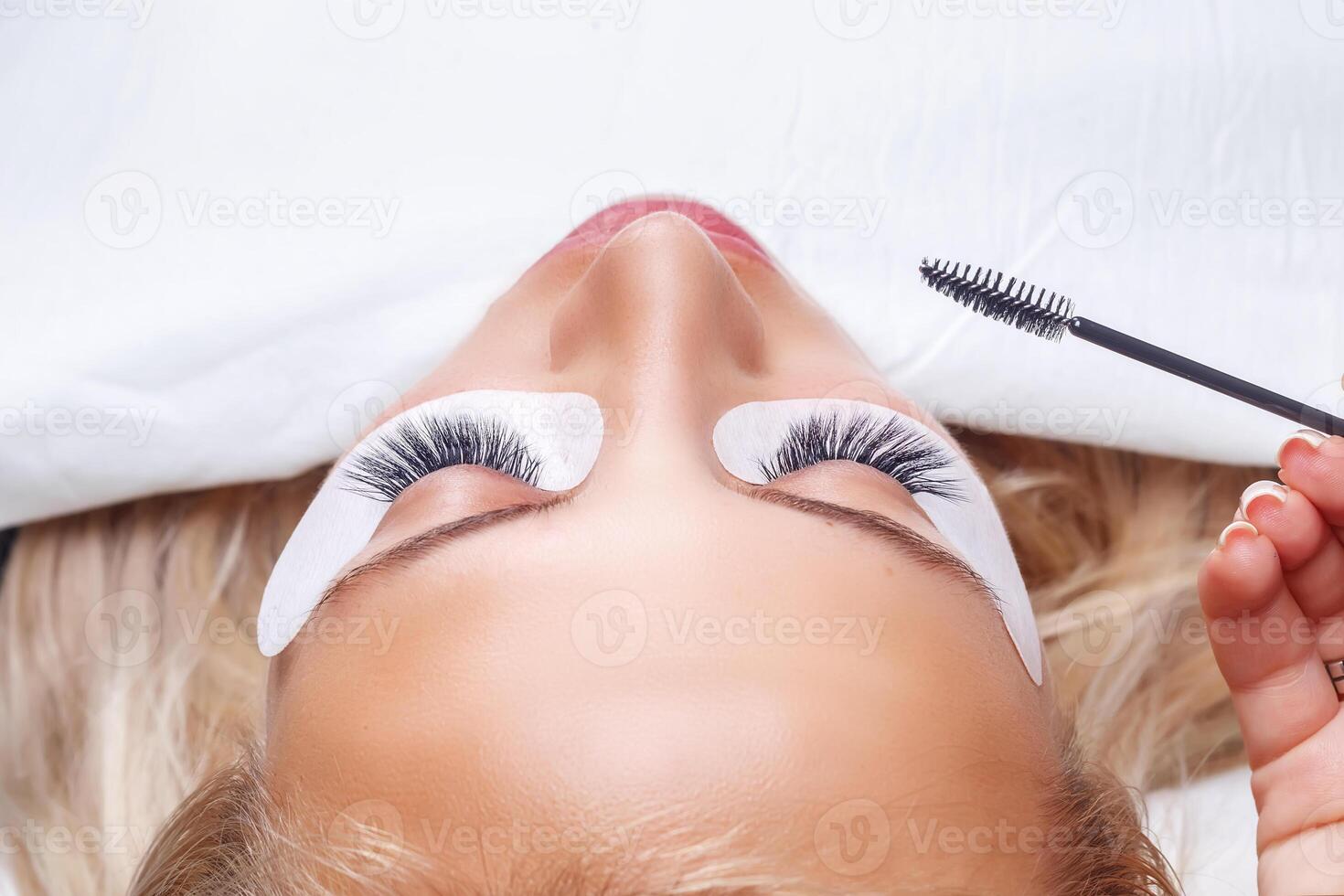 Eyelash Extension Procedure. Woman Eye with Long Eyelashes. Lashes, close up, selected focus. photo