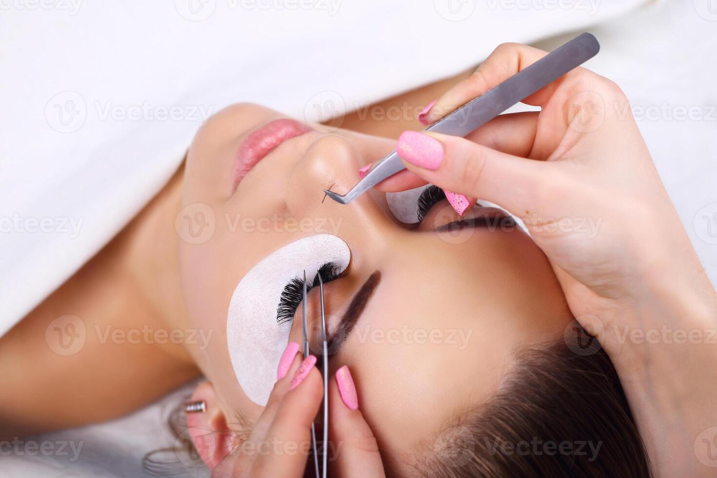 Eyelash Extension Procedure. Woman Eye with Long Eyelashes. Lashes, close up, macro, selective focus. photo