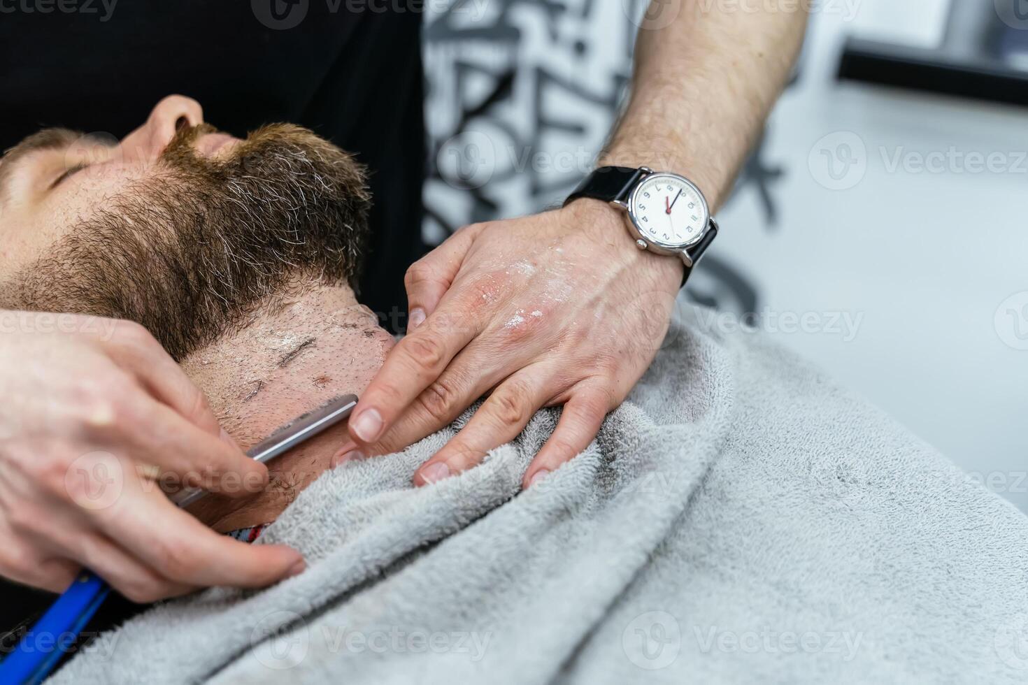 afeitado proceso de barbas en peluquería. cerca arriba Disparo de Barbero hace un Corte de pelo barba cliente con Derecho maquinilla de afeitar. foto