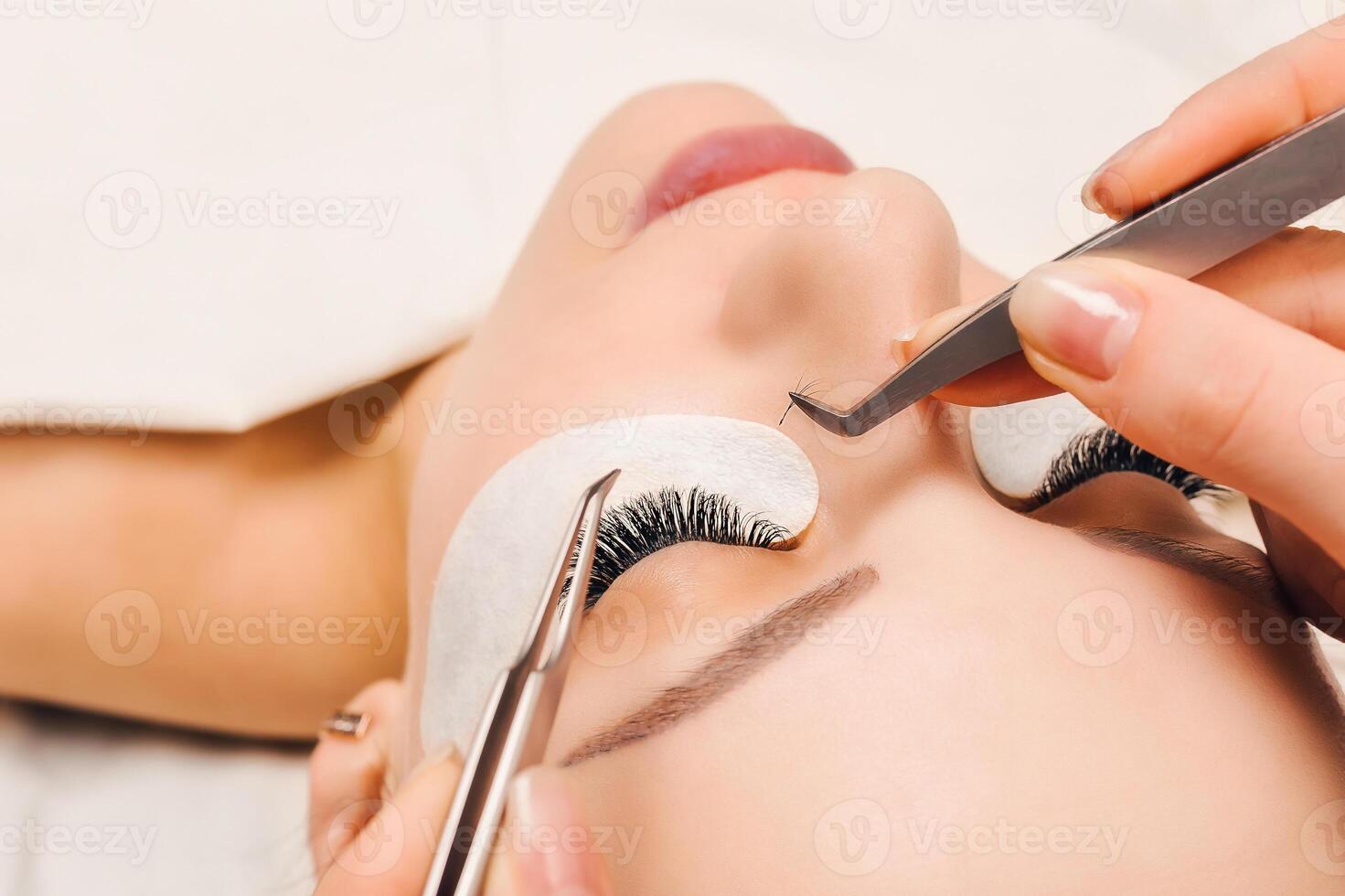 Eyelash Extension Procedure. Woman Eye with Long Eyelashes. Close up, selective focus. photo