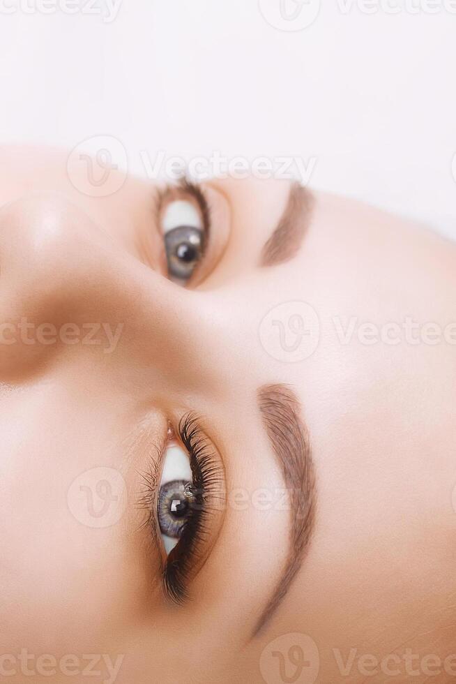 Eyelash Extension Procedure. Woman Eye with Long Eyelashes. Close up, selective focus. photo