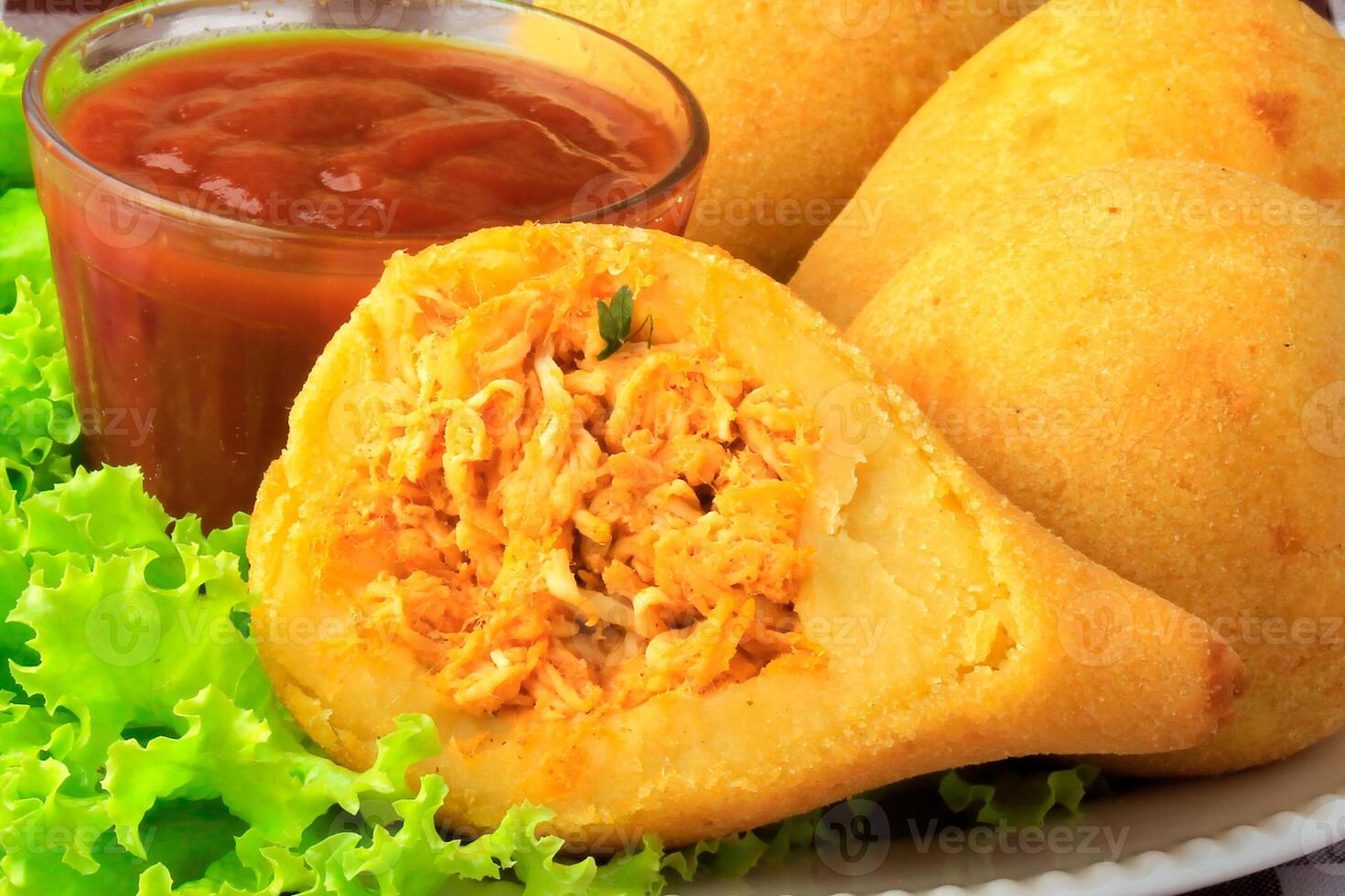 Coxinha in the dish, traditional Brazilian cuisine snacks stuffed with chicken, on rustic wooden table photo