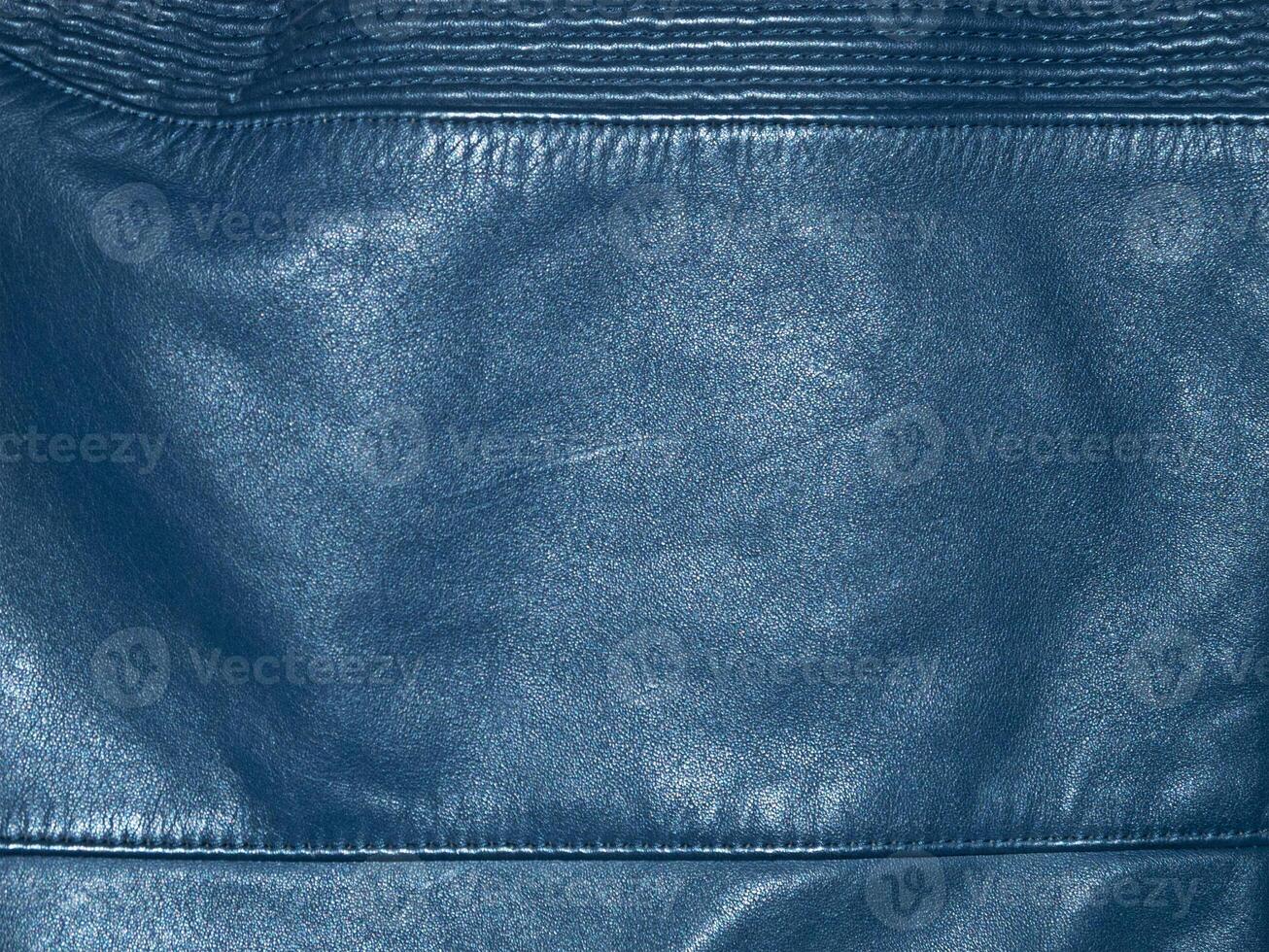 Blue natural dyed leather with seams as a background. A piece of leather clothing. photo