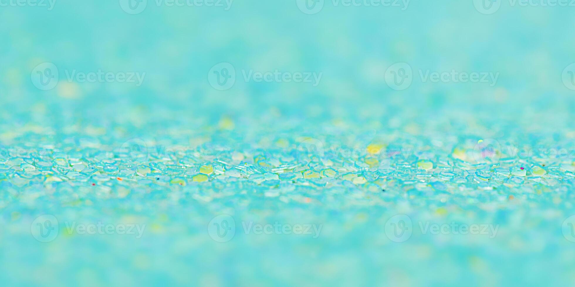 Green background with a thin focal part and a main part in defocus. Macro photo of glitter paper.