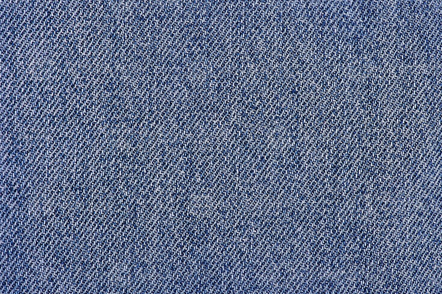 Macro photo of denim fabric with soft focus. Texture of blue jeans as a background.