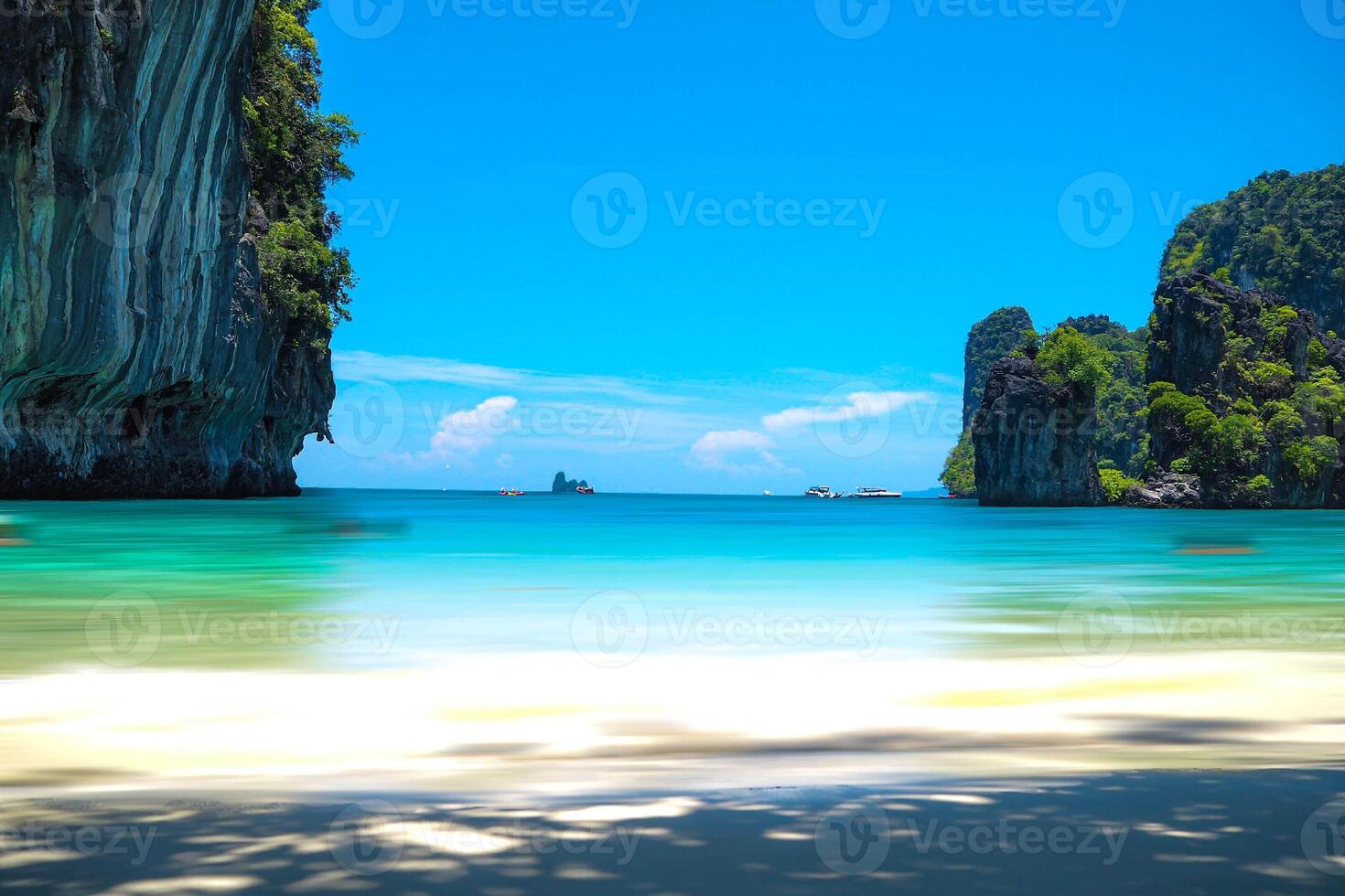Aerial panorama of Thailand's verdant, lush tropical island, National Park Island, with blue and aquamarine the sea, and clouds shining by sunlight in the background. photo