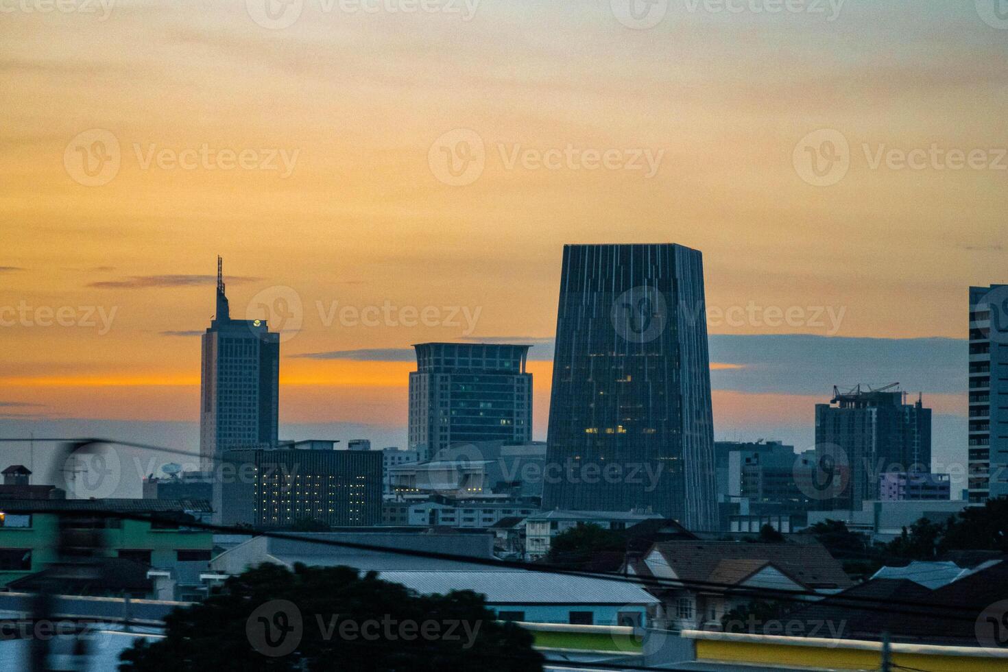 Bangkok, Thailand,2023 - twilight aerial photograph of a metropolis' buildings with golden sky. The places are commercial business districts. photo
