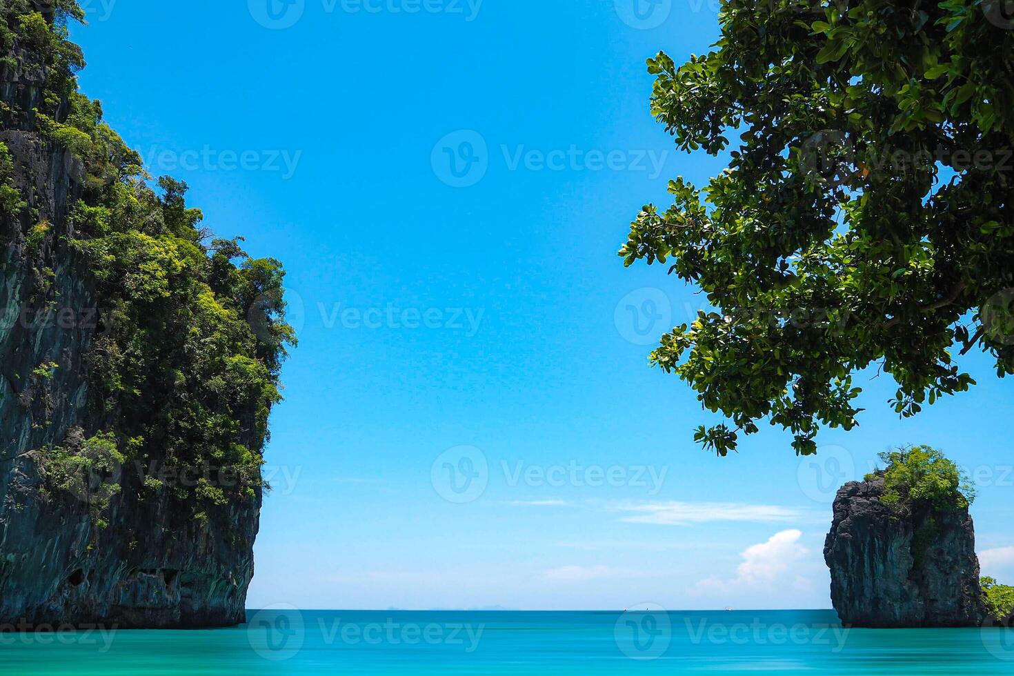 Aerial panorama of Thailand's verdant, lush tropical island, National Park Island, with blue and aquamarine the sea, and clouds shining by sunlight in the background. photo