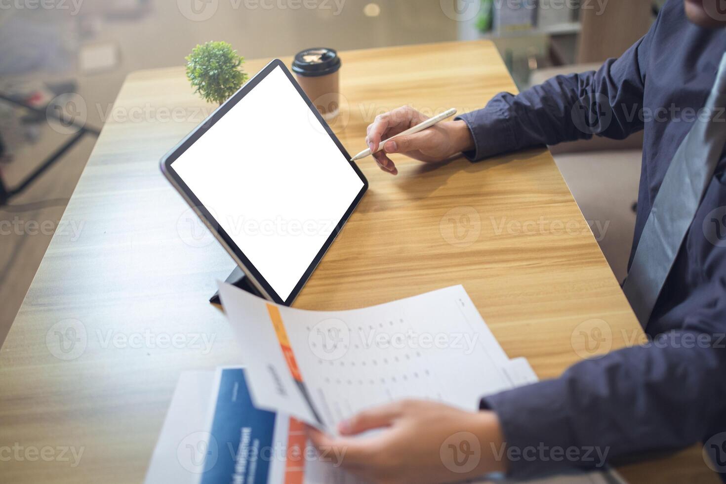 Businessman analyzing statistics on documents with a mock-up screen laptop at a workspace photo