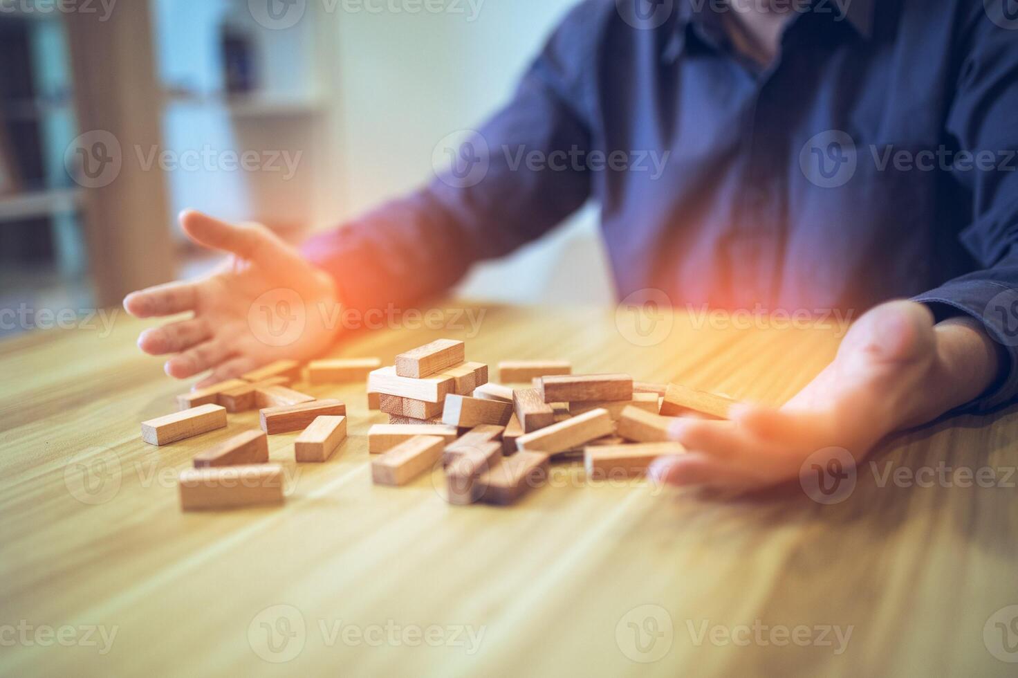 Business strategy concept with hands playing a wooden block tower game, symbolizing risk and stability. Planning risk management photo