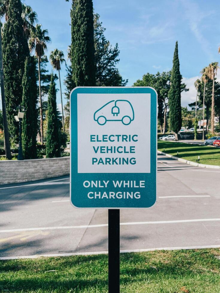 Budva, Montenegro - 17 august 2023. Sign on a pole in the park. Caption. Electric transport parking. Only while charging photo