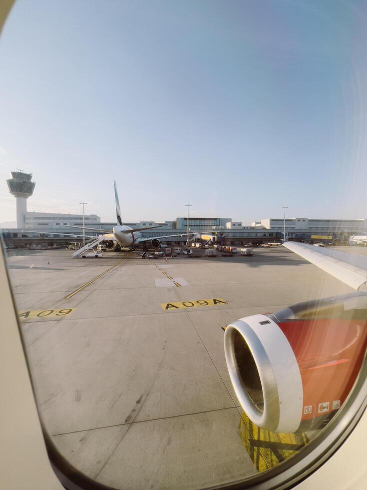 Afines, Greece - 20 august 2023. Porthole view on a plane standing in front of the airport building photo