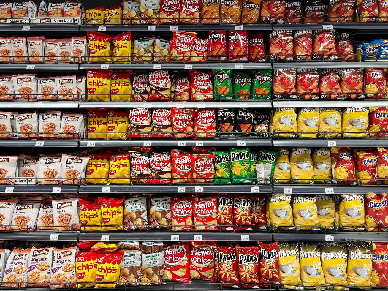 buda, montenegro - 18 agosto 2023. surtido de paquetes con diferente papas fritas en el estantería en el Tienda foto