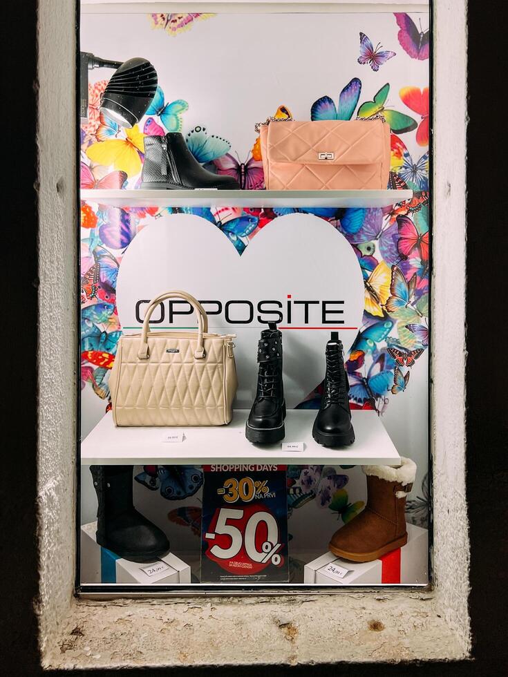 Budva, Montenegro - 25 december 2022. Women winter shoes and handbags in a shop window. Caption. Opposite photo