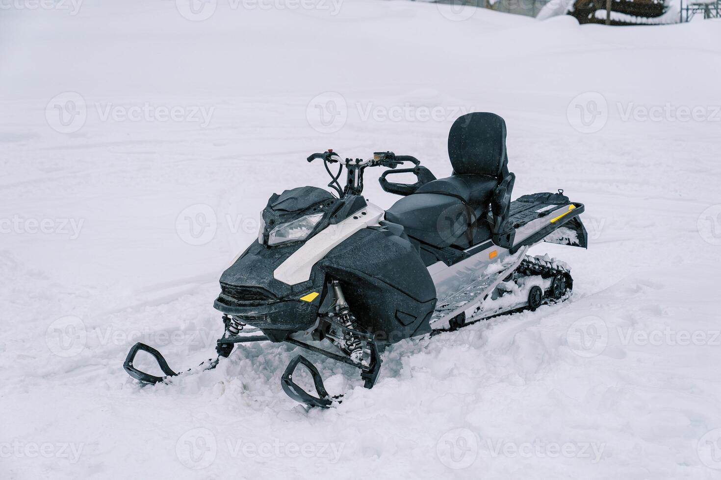 Black snowmobile stands on a snowy track photo