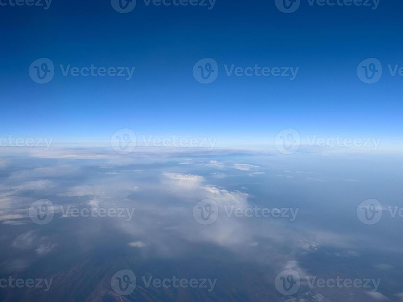 View from the porthole to the blue horizon and the earth under the clouds photo