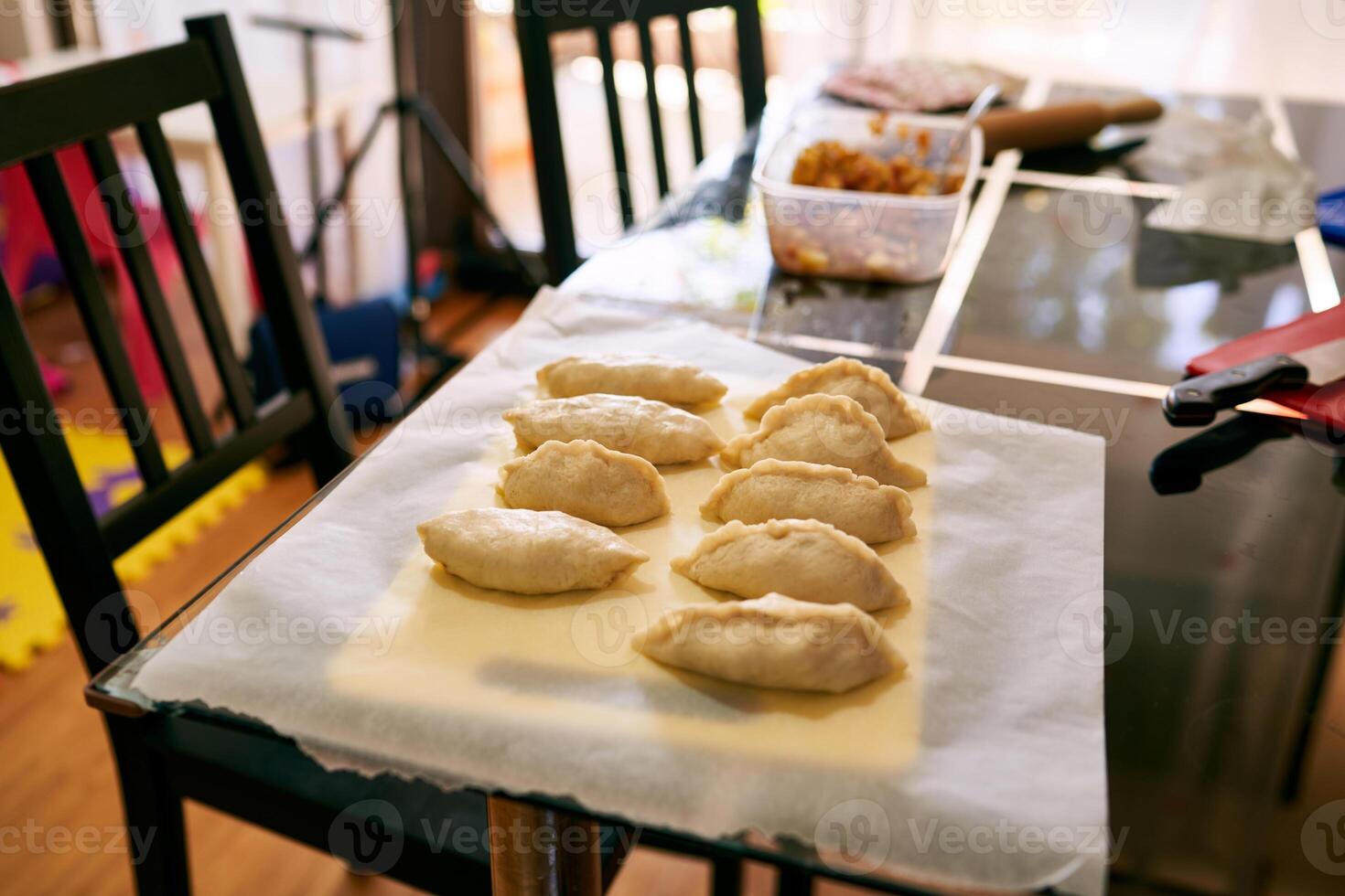 Raw stuffed buns lie on baking paper on the table photo
