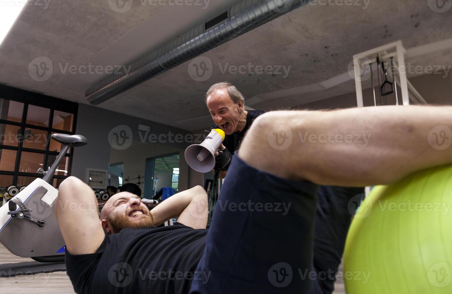 senior trainer screaming with a megaphone at the young athlete photo