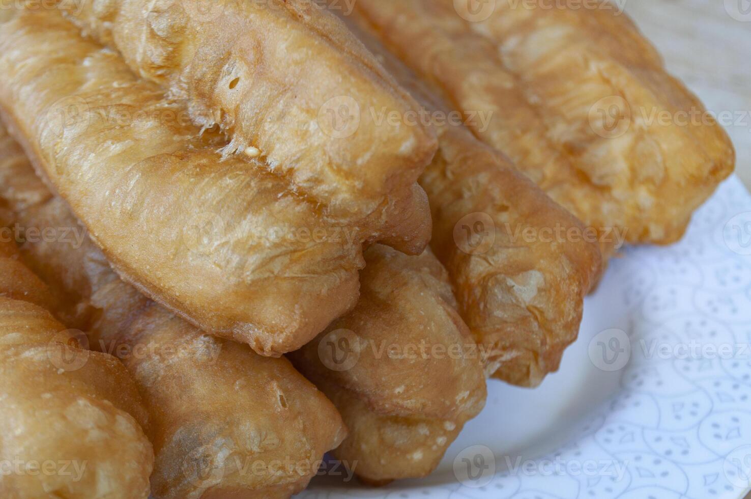 Close up of cakoi or Youtiao on white plate with customizable space for text. Asian food concept photo