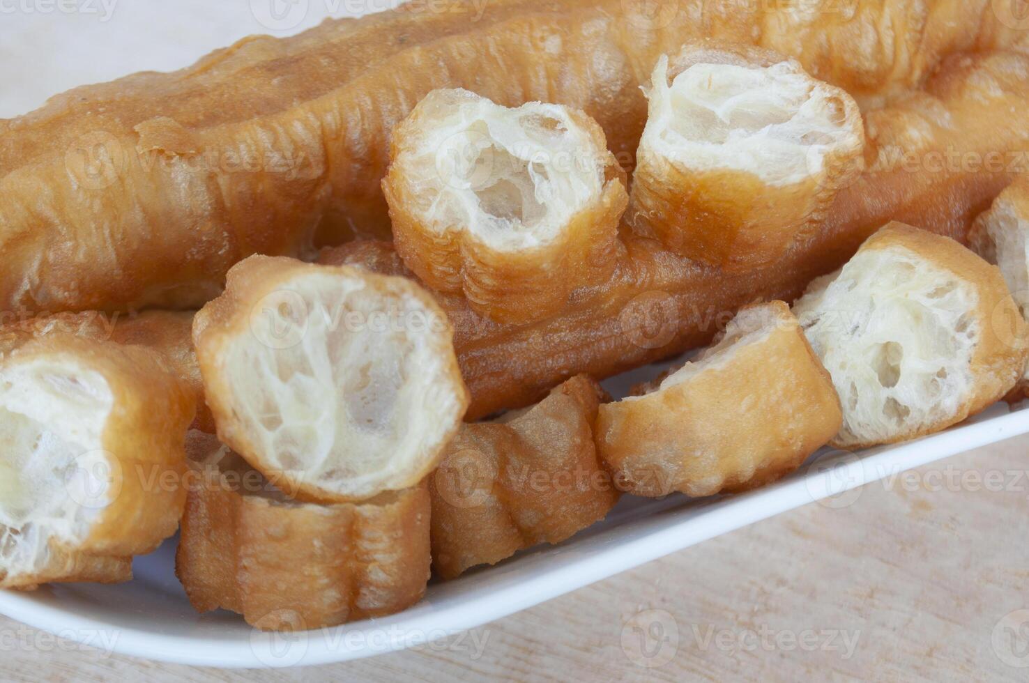 Close up of cut cakoi or youtiao cake on white plate. Asian food concept photo