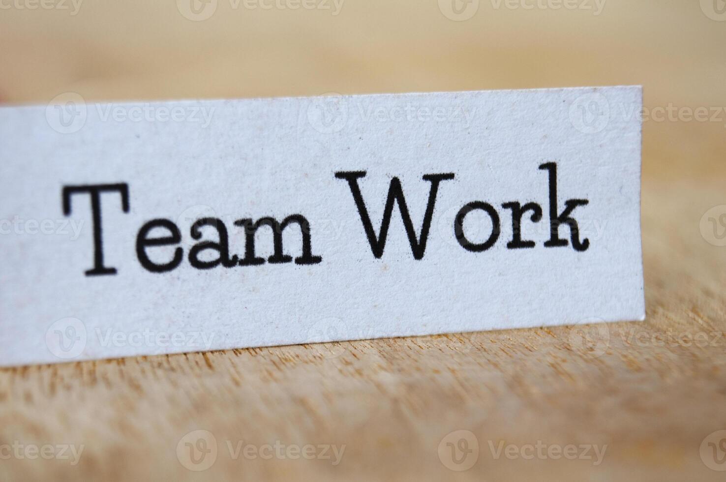 Team work text on white paper on wooden table photo