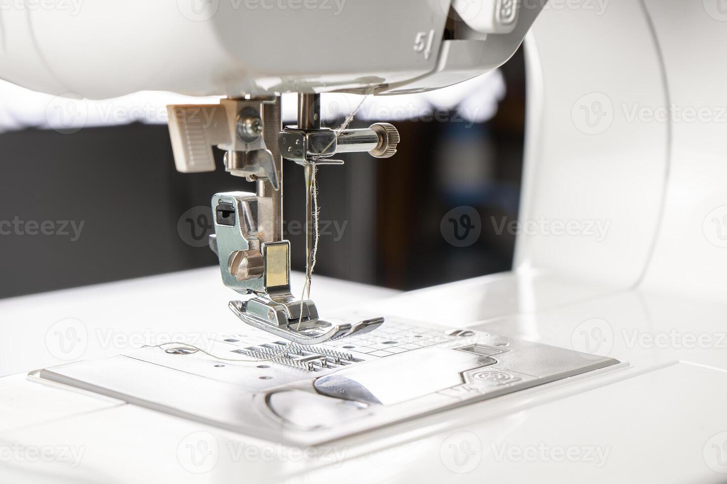 Modern white sewing machine presser foot closeup, macro photo