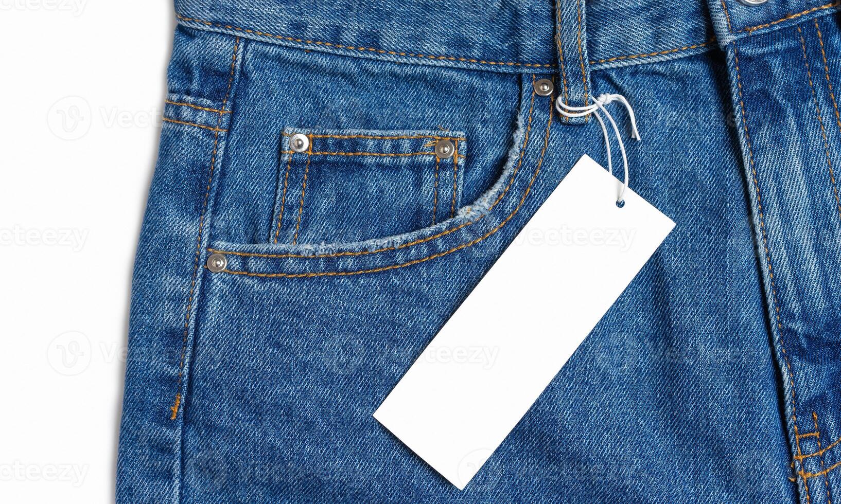Front side pocket of blue jeans pants and price tag close-up isolated on white background photo