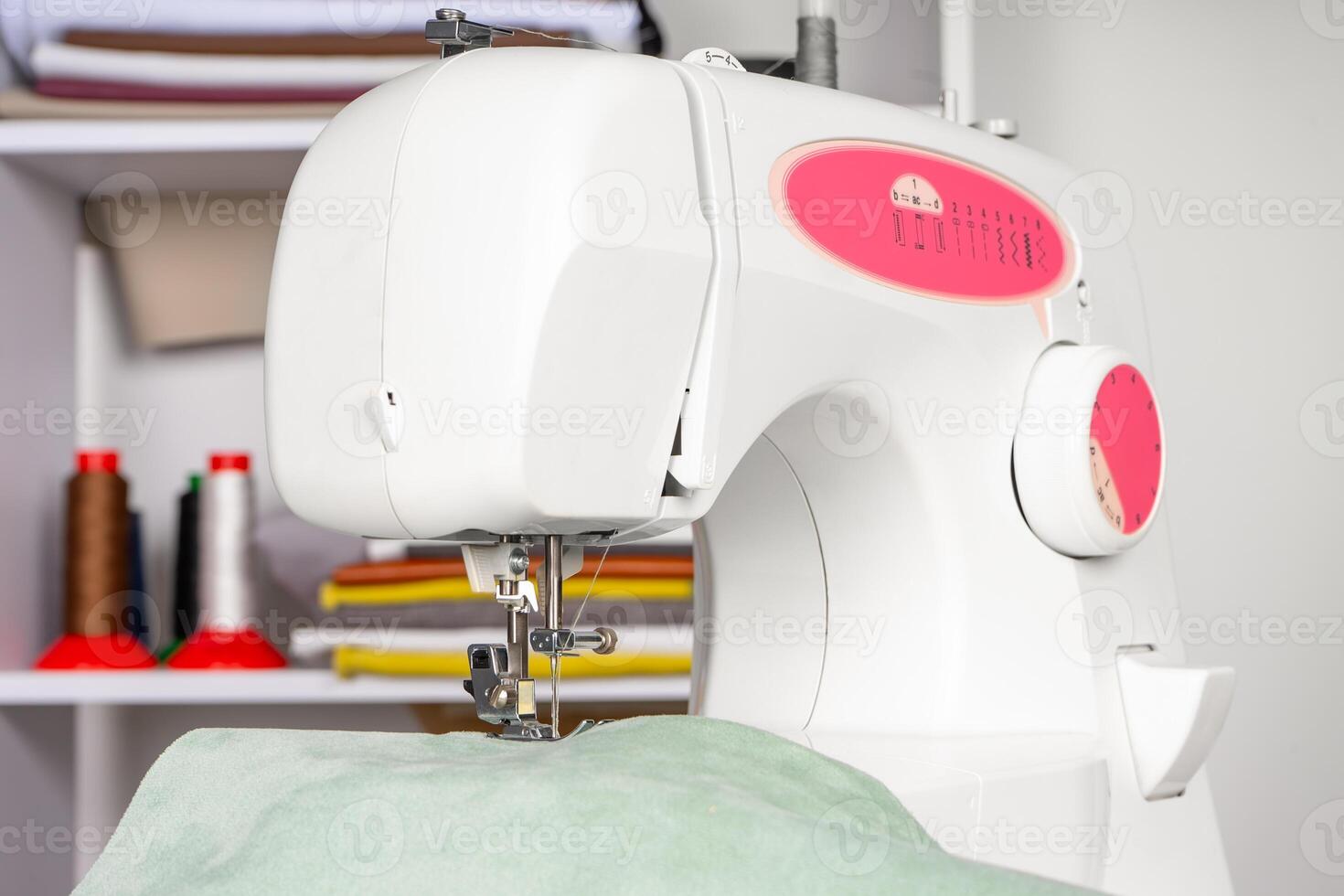 moderno de coser máquina prensador pie con verde tela y hilo foto