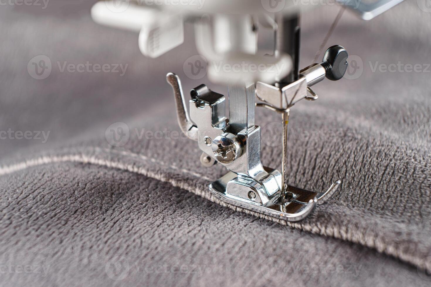 Modern sewing machine with gray velours fabric close up photo