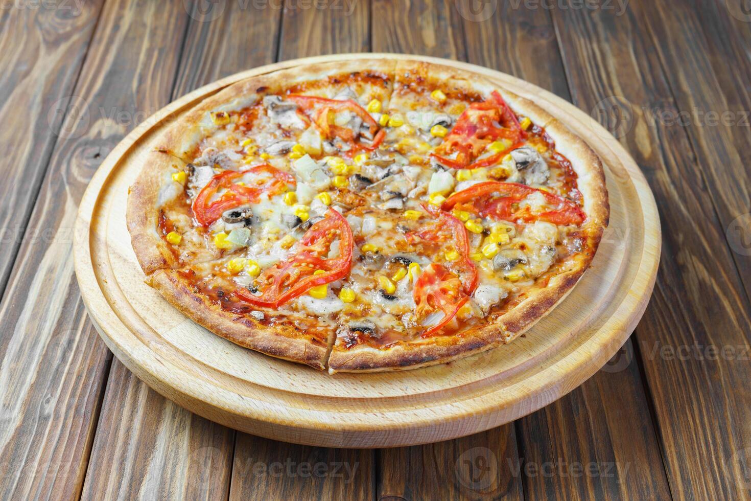 italiano Pizza con Derretido queso Mozzarella queso hongos, maíz y tomate en marrón de madera antecedentes. foto