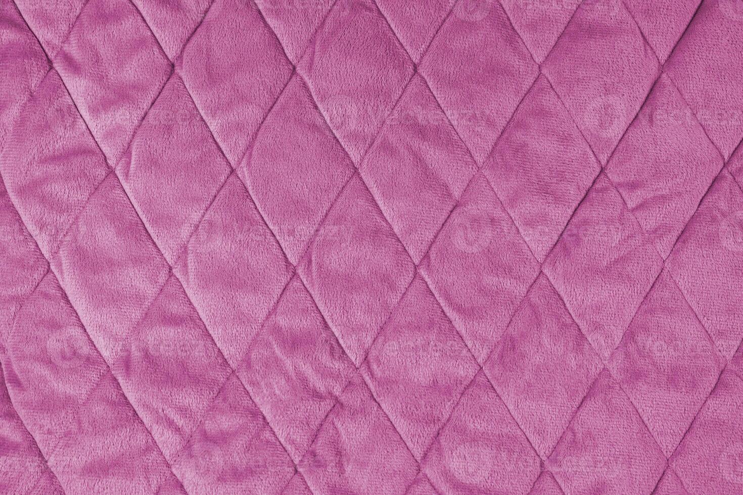 Quilted pink velours fabric background, wrinkled soft blanket surface photo