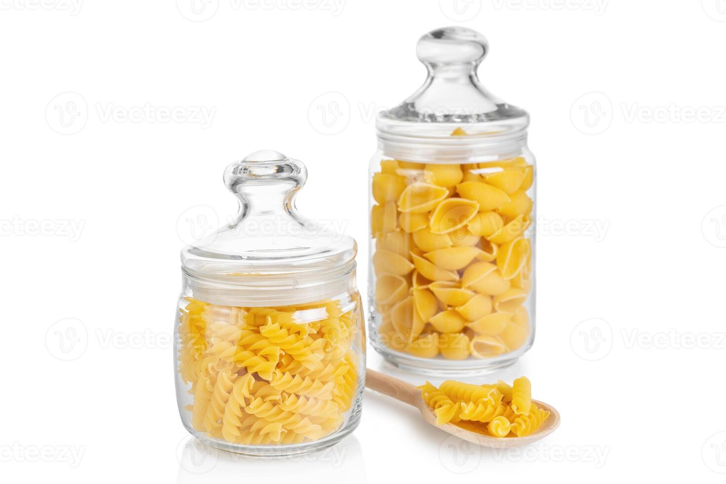 Raw pasta in glass jar isolated on white background photo