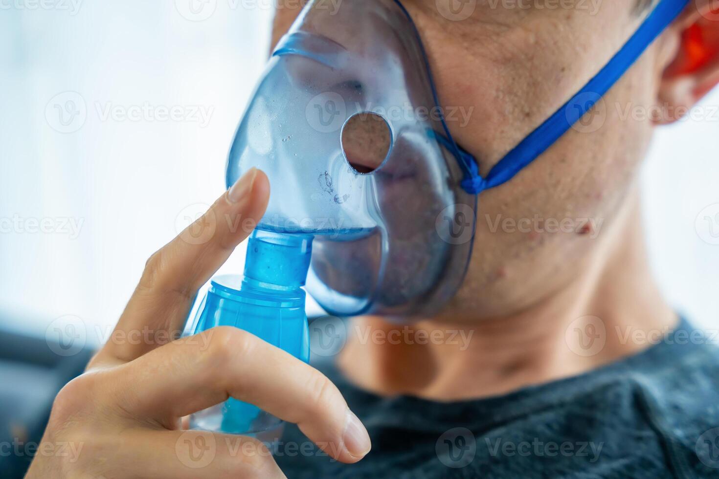 cerca arriba ver de insalubre hombre vistiendo nebulizador máscara en hogar. salud, médico equipo y personas concepto. alto calidad foto