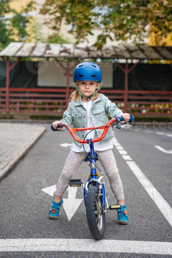pequeño niña a paseo público bicicleta en uno de tráfico patio de recreo en praga, checo república, Europa. alto calidad foto