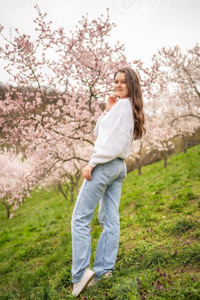 Lovely young woman in a blooming pink and white garden Petrin in Prague, spring time in Europe. High quality photo